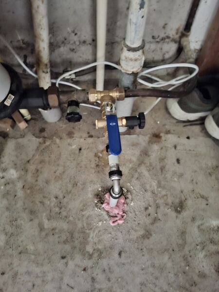 Nieuwe hoofdkraan met blauwe hendel aangesloten op de waterleiding