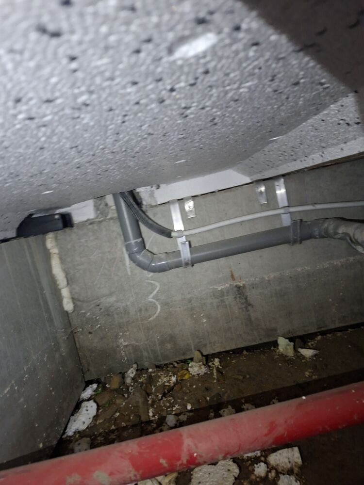 Netjes gebeugeld waterleiding- en afvoerwerk in een kruipruimte
